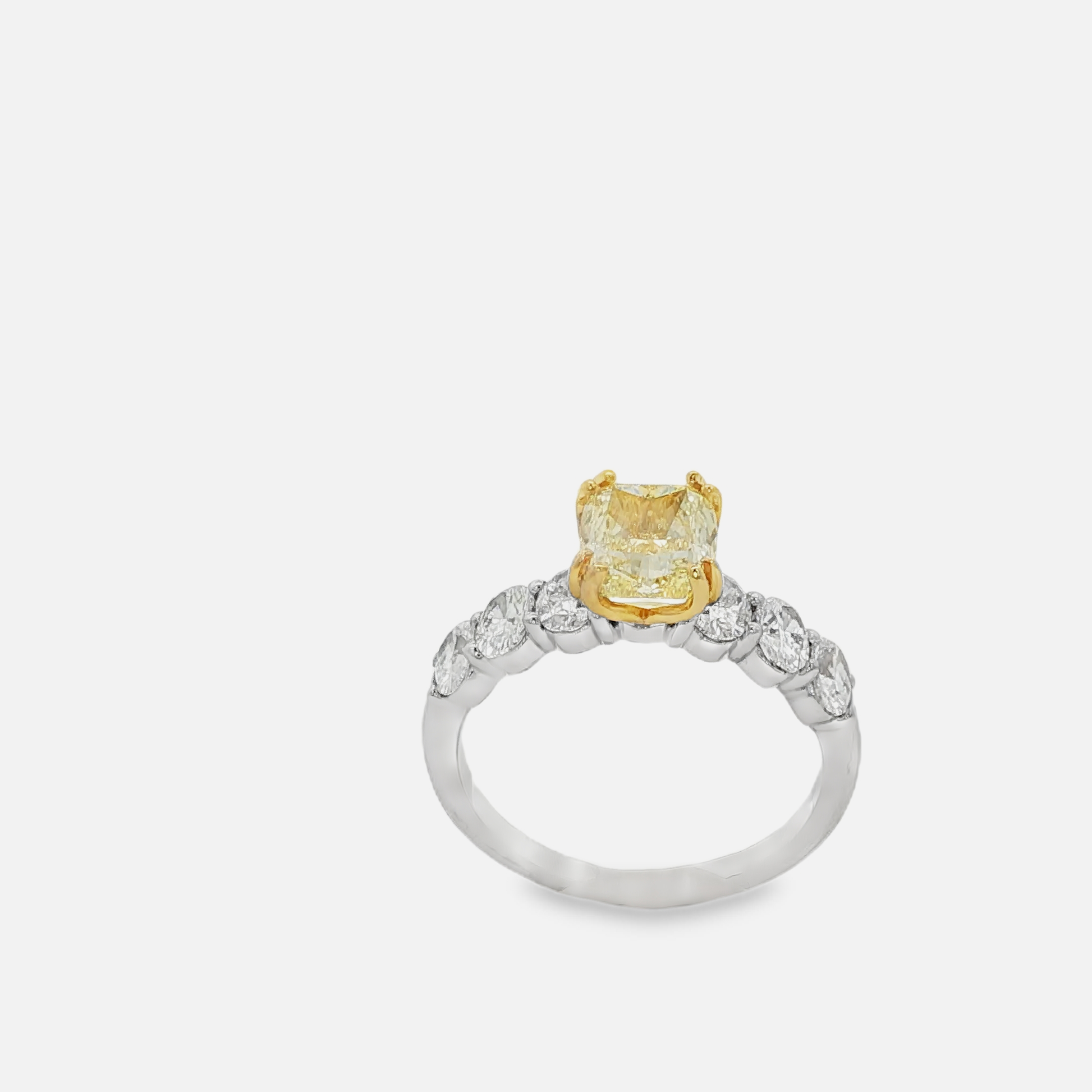 Ring with a yellow gemstone and diamond accents on a white background