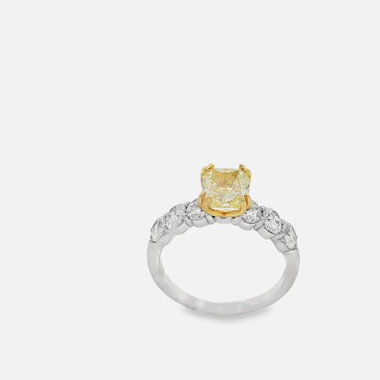 Ring with a yellow gemstone and diamond accents on a white background